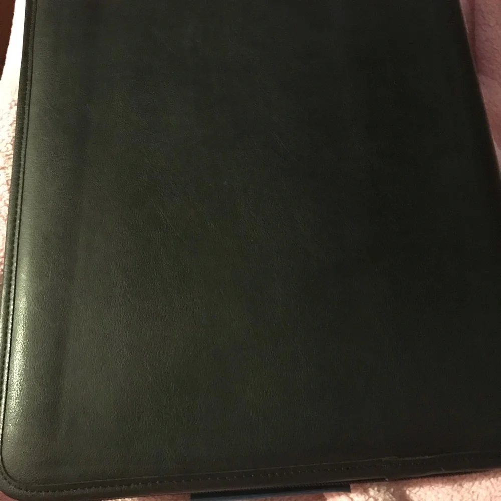 Black portfolio with wraparound zipper. Writing pad, slide and zippered pockets.